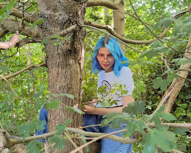 Vladyslava Bondar in a maple
tree, holding a branch to protect against rusalky.